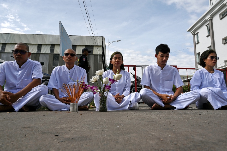 Cambodian environmental activists from the group Mother Nature sit near barricades blocking a street to the municipal court in Phnom Penh, Cambodia, June 5, 2024.